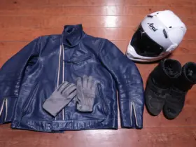 Motorcycle helmet, leather jacket, gloves and boots arranged together
