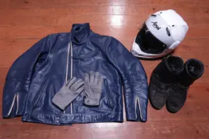Motorcycle helmet, leather jacket, gloves and boots arranged together