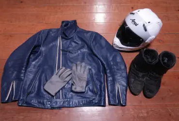 Motorcycle helmet, leather jacket, gloves and boots arranged together