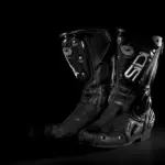 Pair of black motorcycle riding boots on a dark background