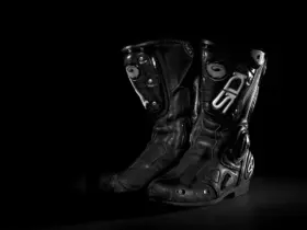 Pair of black motorcycle riding boots on a dark background