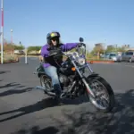 Helmeted rider wearing riding clothing on a black cruiser motorcycle