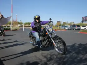 Helmeted rider wearing riding clothing on a black cruiser motorcycle