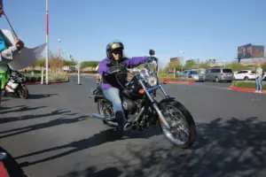 Helmeted rider wearing riding clothing on a black cruiser motorcycle