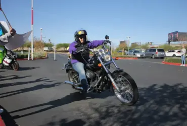 Helmeted rider wearing riding clothing on a black cruiser motorcycle